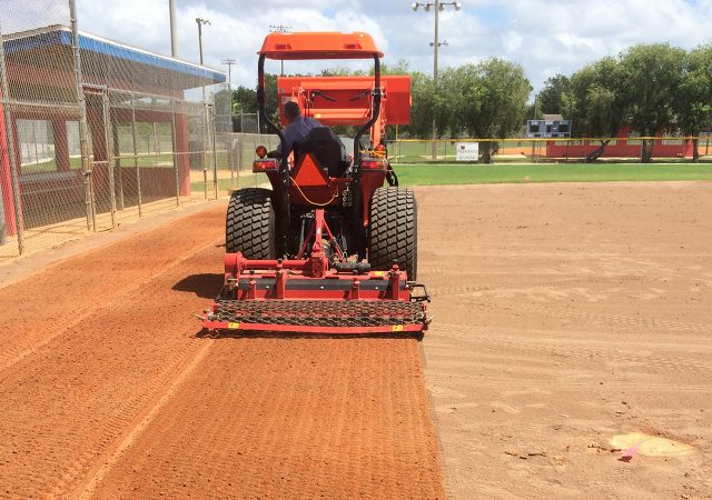 preparing the infield by leveling the dirt