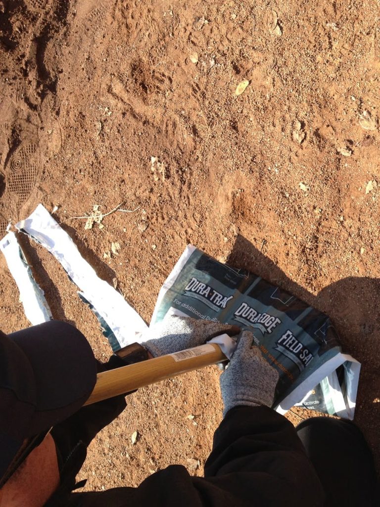 gentleman putting tool on bag of fertilizer
