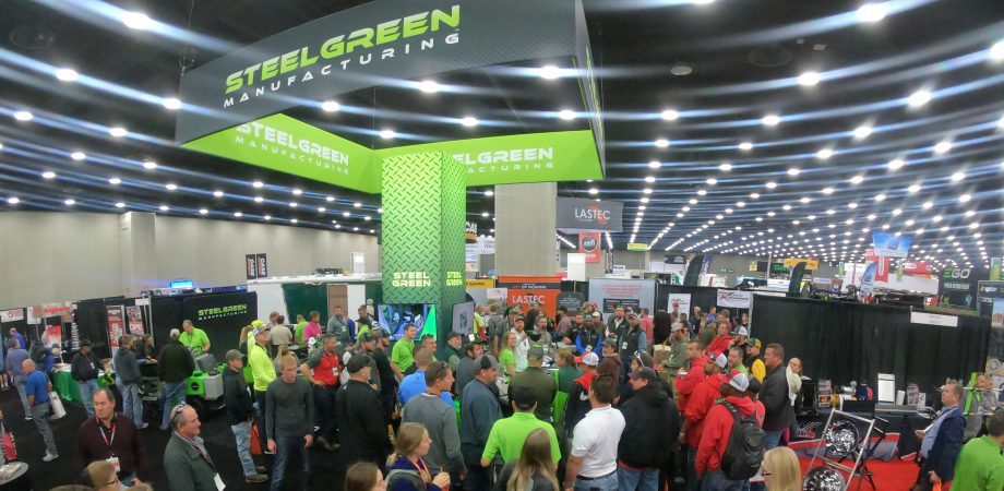 tons of people standing around Steel Green manufacturing tent at venue