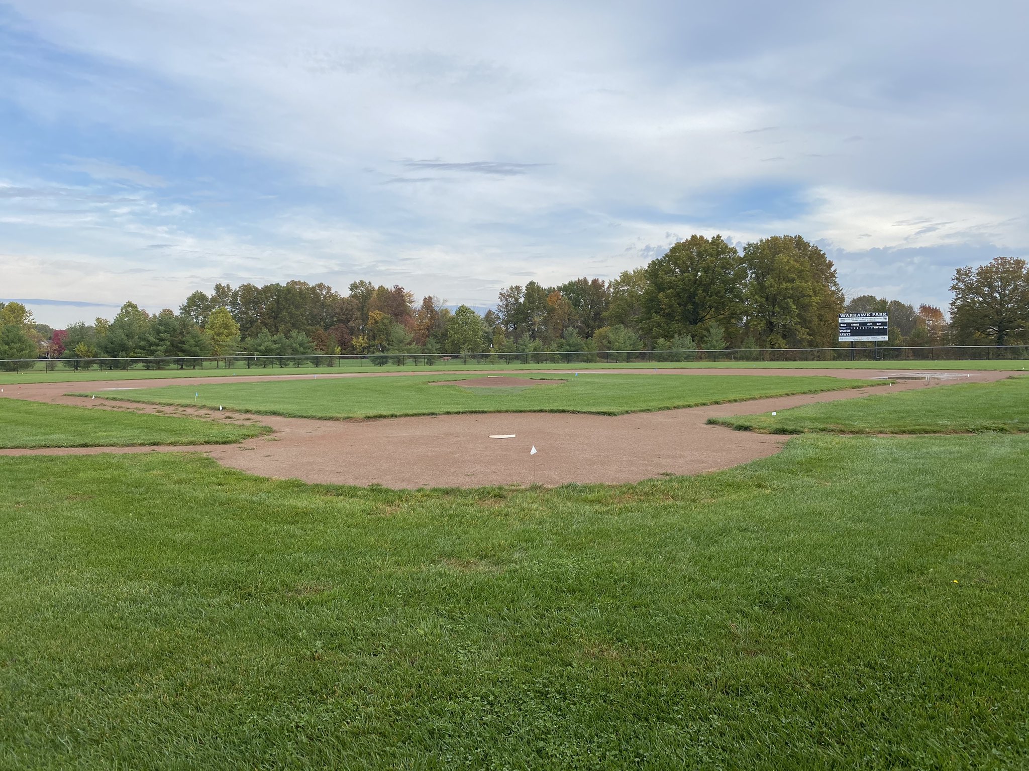 Baseball field with scoreboard in the outfield.