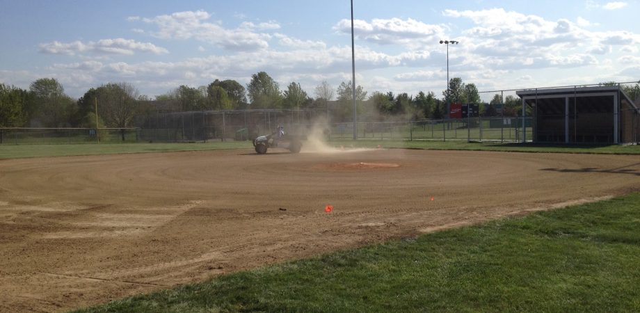 tractor driving on infield and creating dust