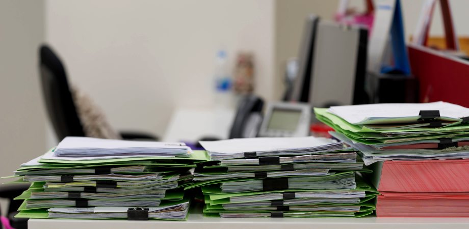 many paper documents on table in office