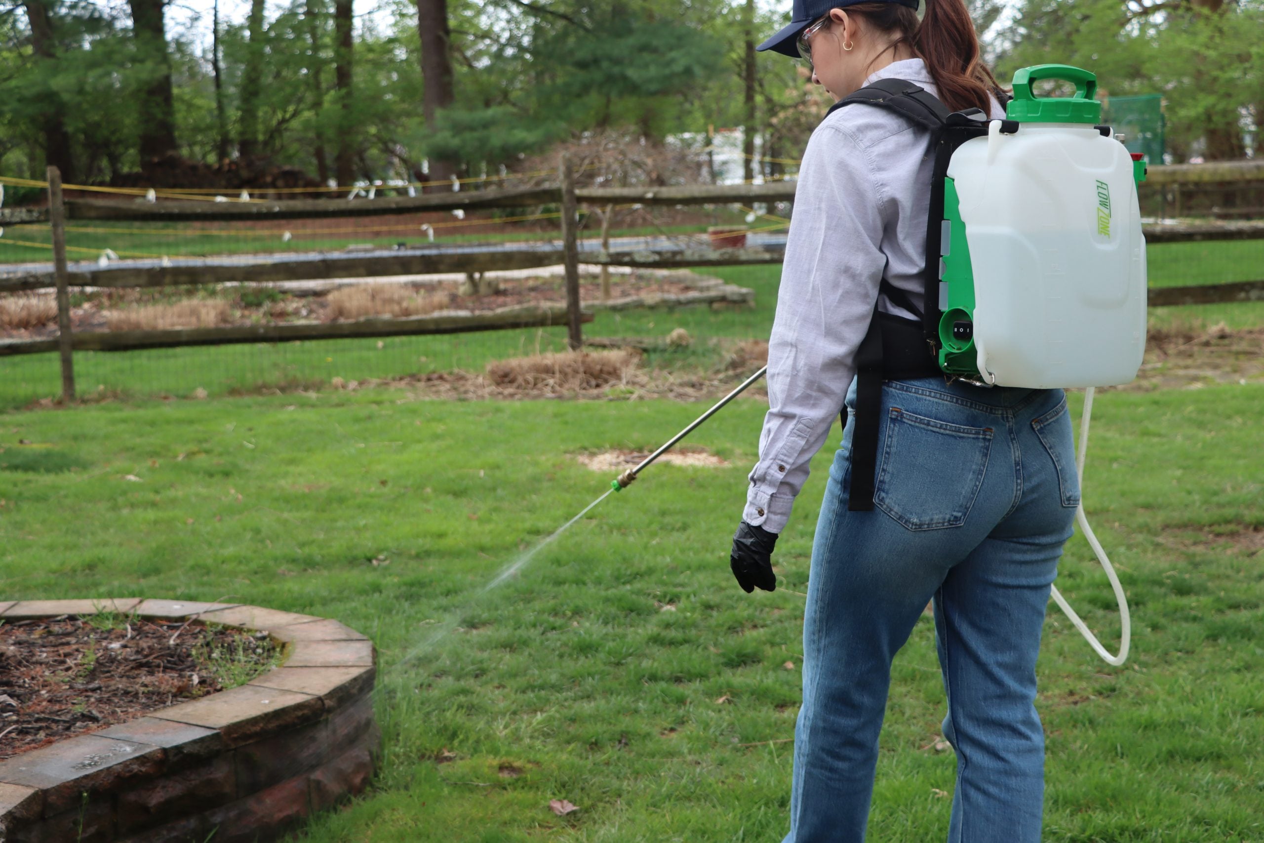 woman using FlowZone backpack sprayer