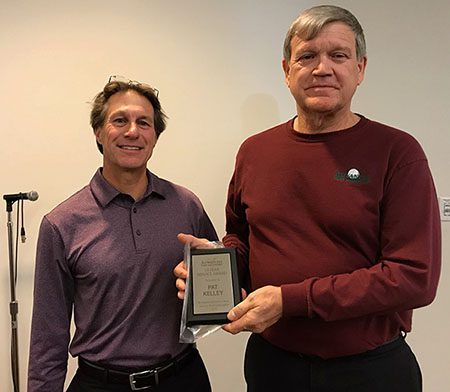 Pat Kelley smiling while holding his award