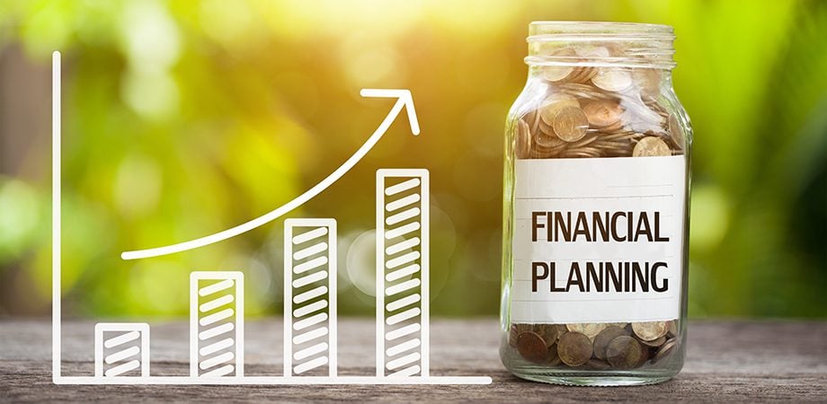Financial planning word with coin in glass jar and graph up.