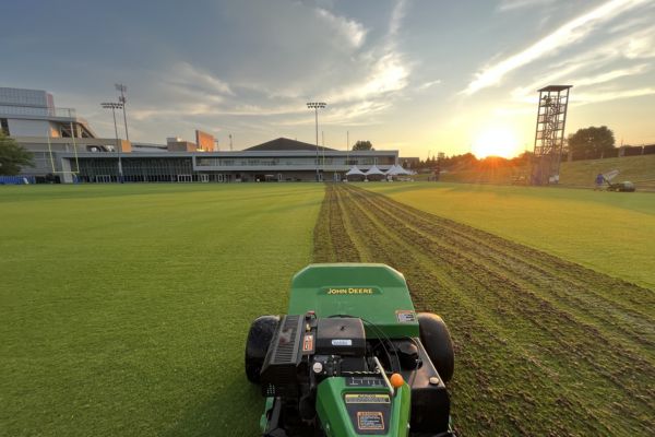 Mower mowing in the evening on University of Kentucky football field