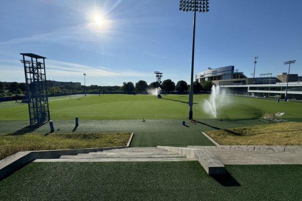 Wide shot of University of Kentucky practice field with irrigation system running